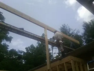 Carpenter setting a ridge beam over a new addition frame — Ice Dam Removal by Roofing Brothers in Brush Valley