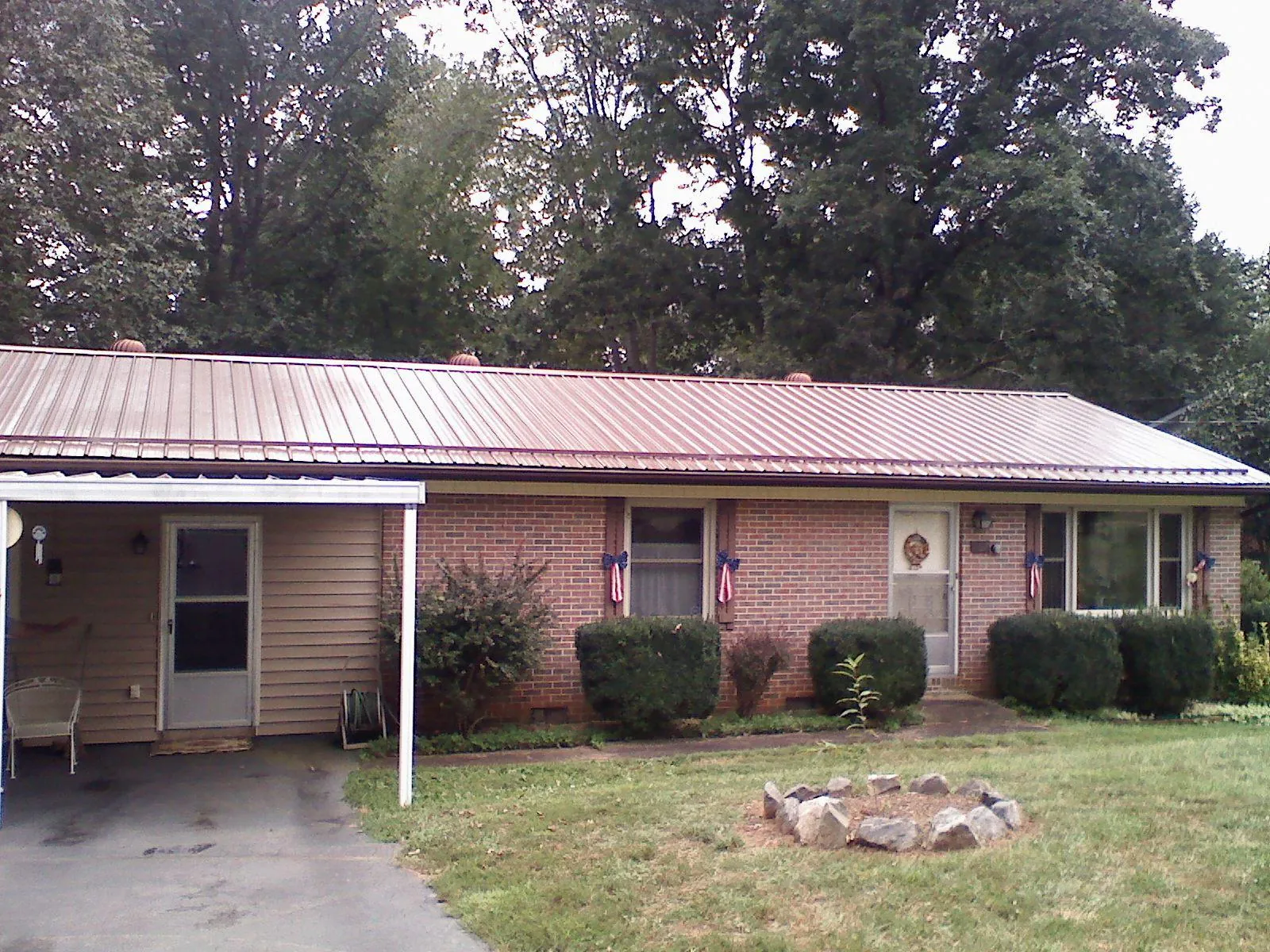 Bronze metal roof and carport on a brick ranch home — Roof Repair work by our crew in Brush Valley